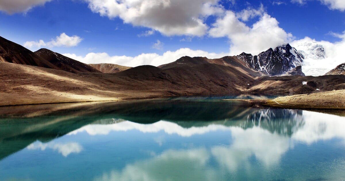 Gurudongmar Lake surrounded by snow-capped mountains in Sikkim, India